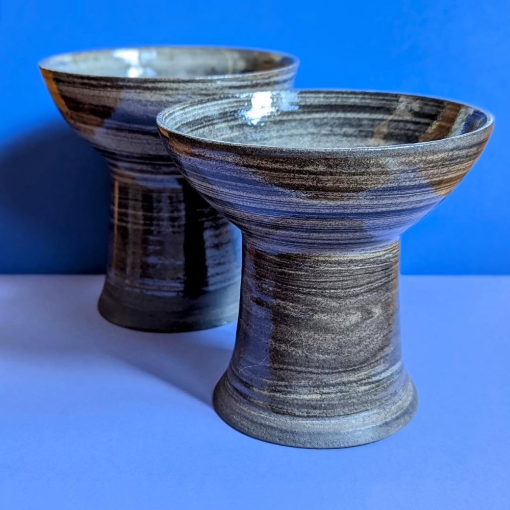 Bols piédestal en grès à l'émail brun-gris strié, sur un papier de fond bleu cobalt
